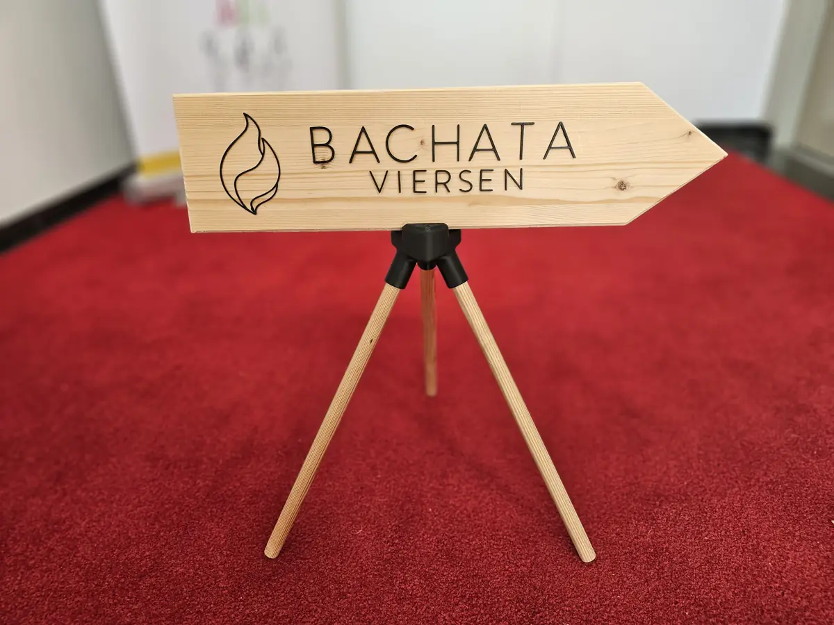 Holzschild Bachata Viersen auf einem Dreibein aus Holzstäben